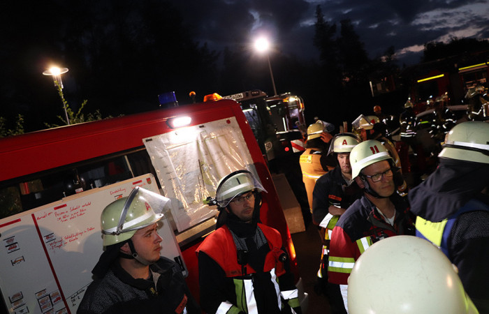 Die Einsatzleitung hat ist ein gutes Stück vom Eingang entfernt und plant hier die nächsten Schritte.